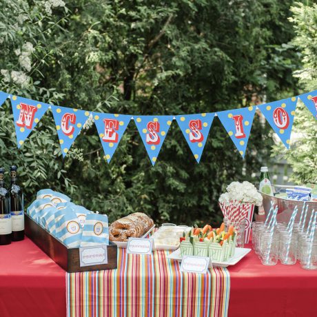 Concession stand for a circus-themed birthday party in sky blue and red with bunting, pretzels and popcorn