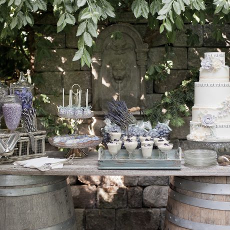 Lavender-inspired wedding sweets table with cake, blackberry mousses in champagne coupes, lavender candy and cake pops