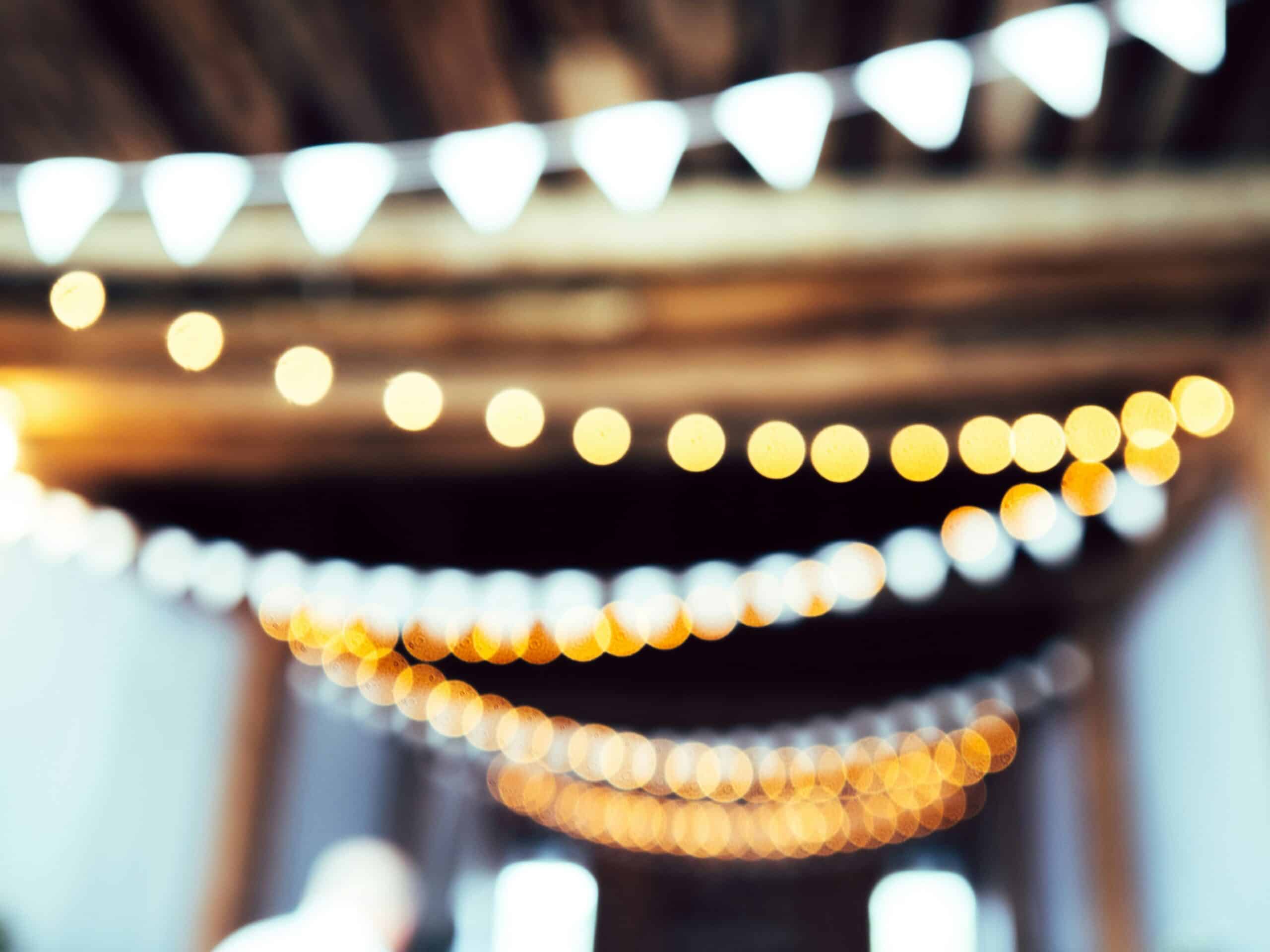 String lights and white bunting blurred into a background