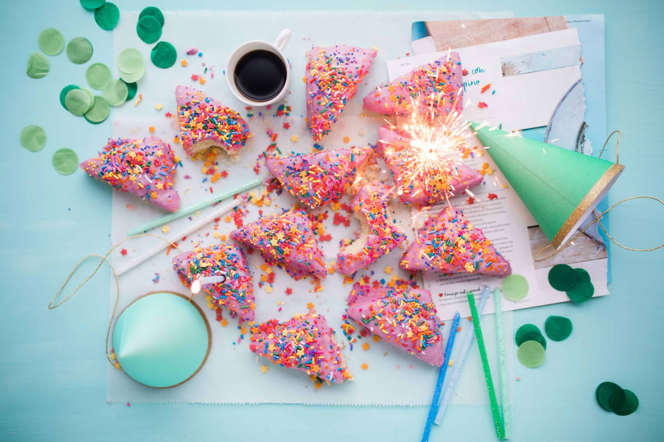 Green party hats and pieces of cake with pink icing and sprinkles makes for a very festive look