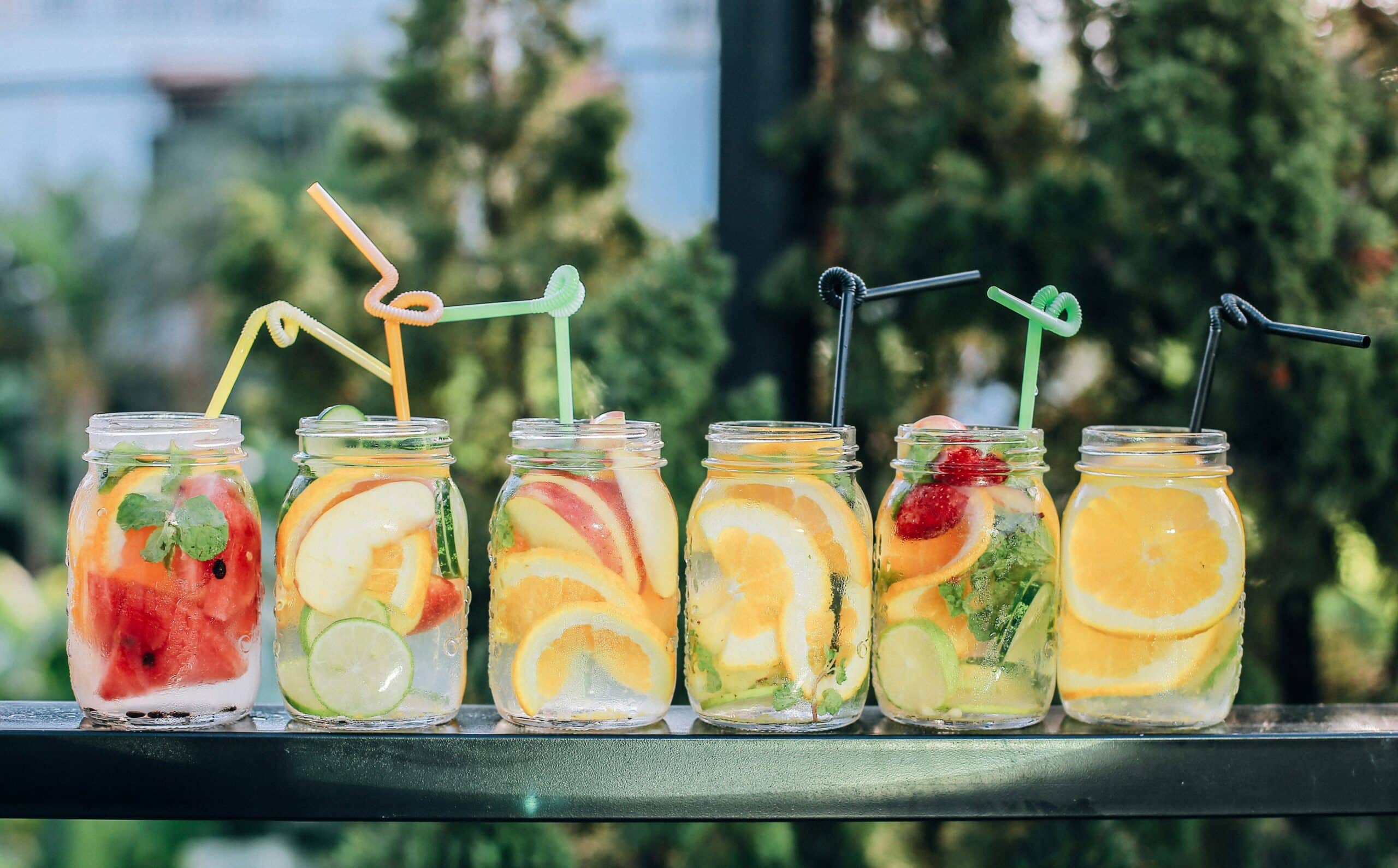 Variety of mocktails with floating fruits in Mason jars